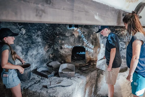 Familie erkundet historischen Steinofen in altem Bäckereimuseum